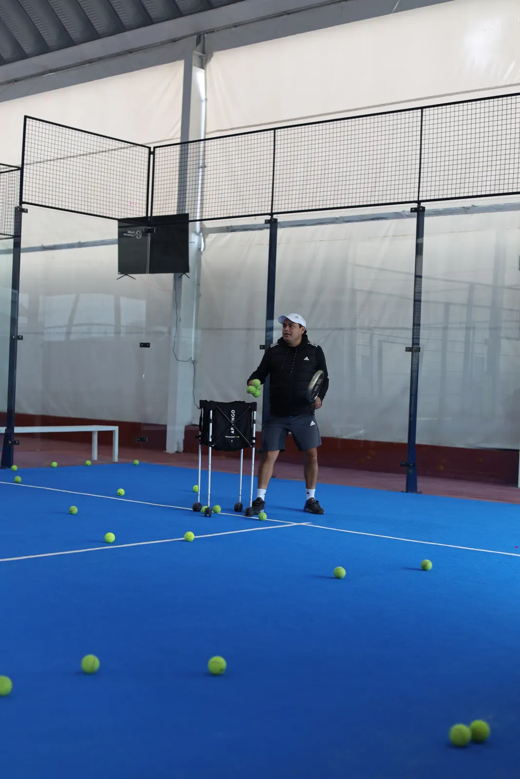 El coach lanzando pelotas durante una clase