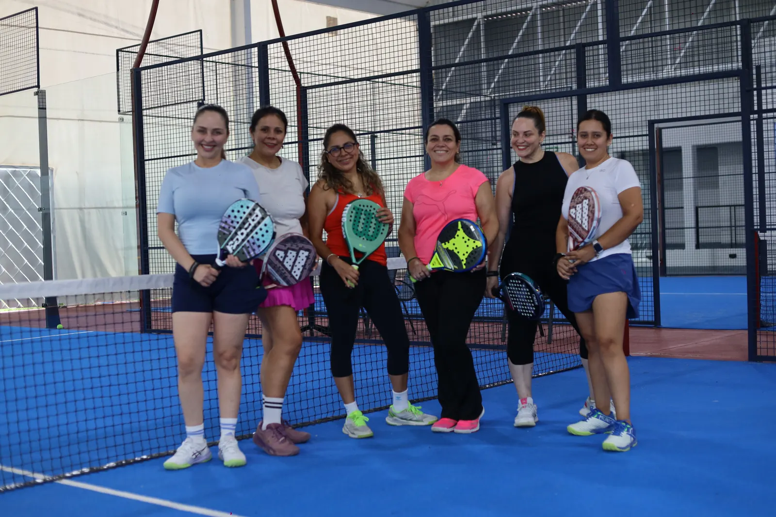 Equipo reunido en la cancha de pádel después de un torneo